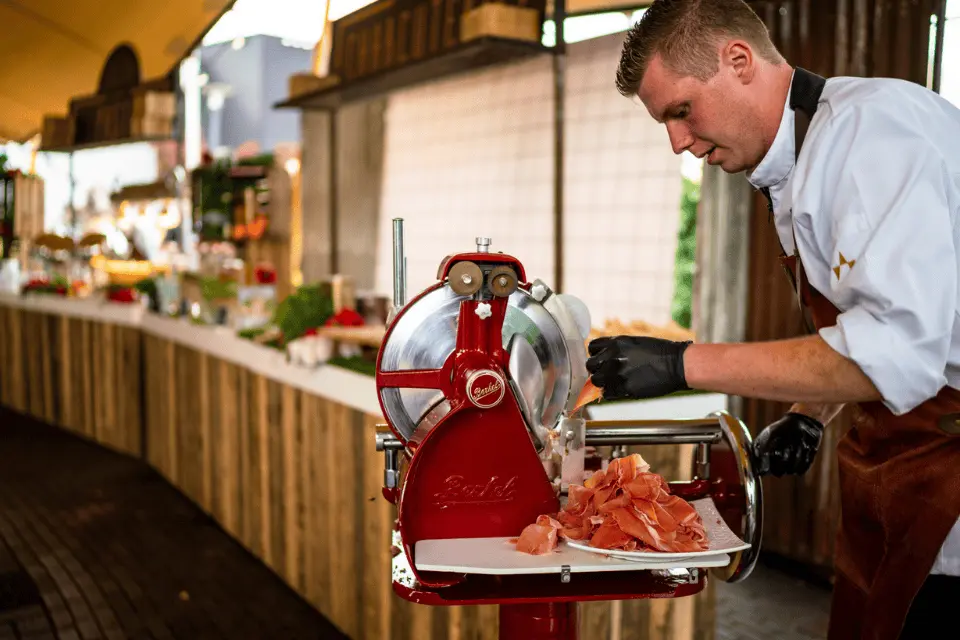 Authentieke Berkel snijmachine met ambachtelijk gesneden vlees op zakelijk event