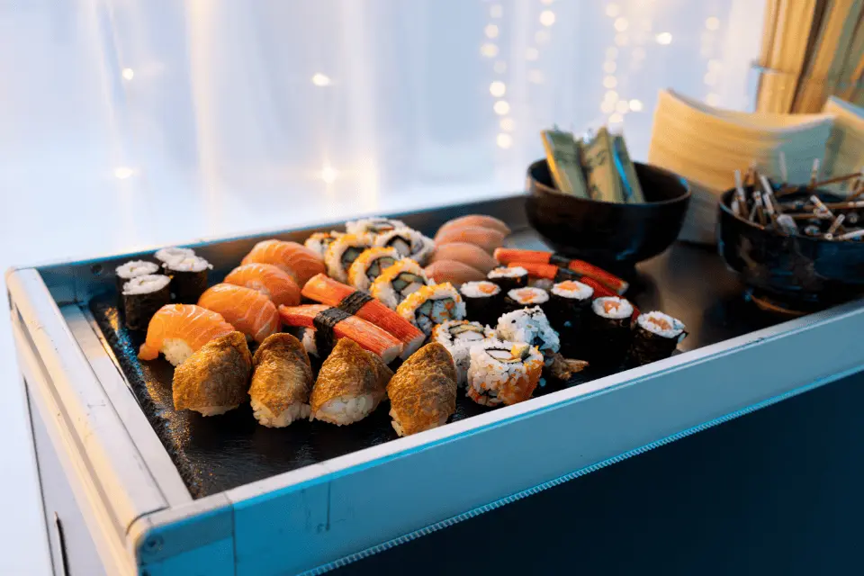 Sushi trolley met maki, nigiri en sashimi tijdens zakelijk walking dinner