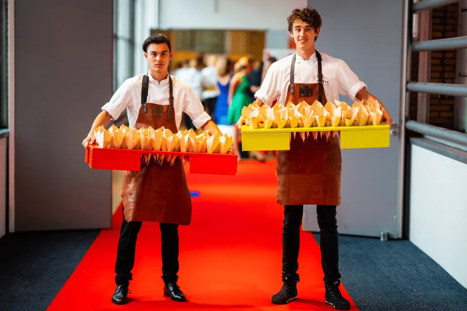 Ventbakken met kleine gerechten geserveerd tussen gasten op zakelijk event